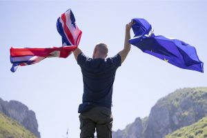 UK England Flag and European Union EU Flag holded by a man.